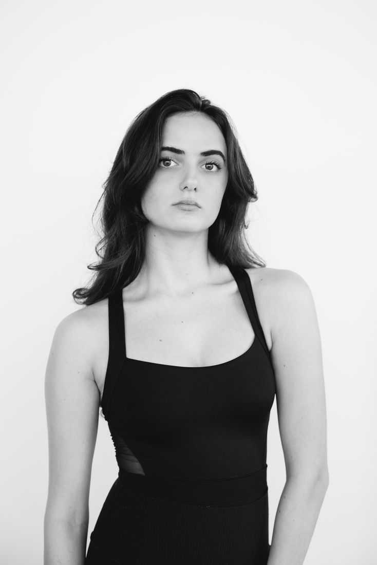 Black and white studio portrait of a young woman looking straight into the camera