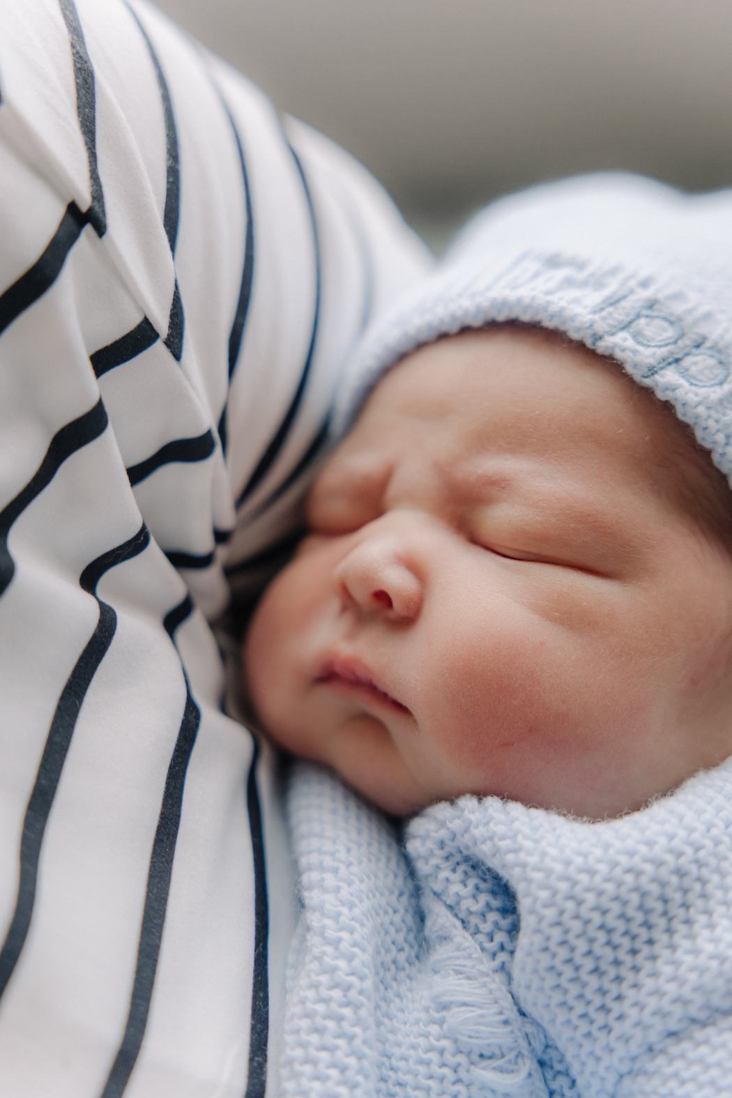 A newborn asleep in a blue hospital blanket